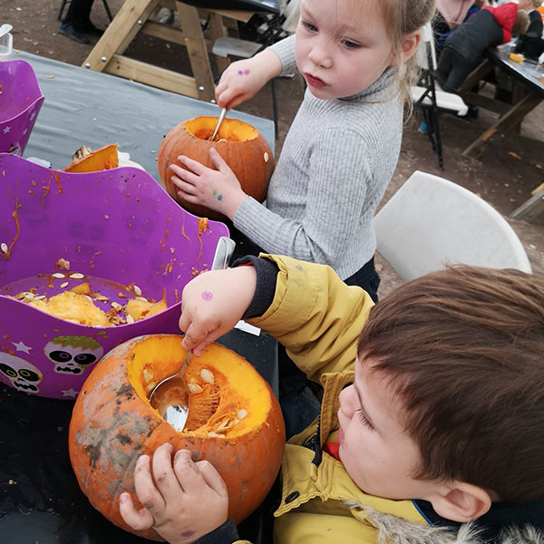 children carving pumpkins