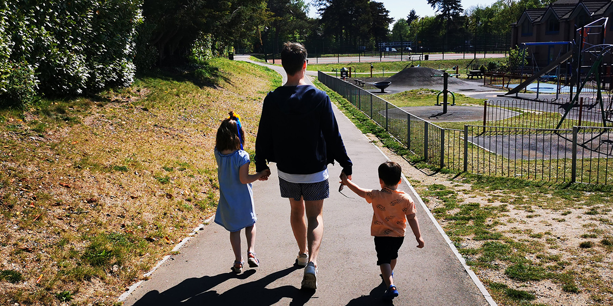 a dad and two children walking outside, keeping healthy