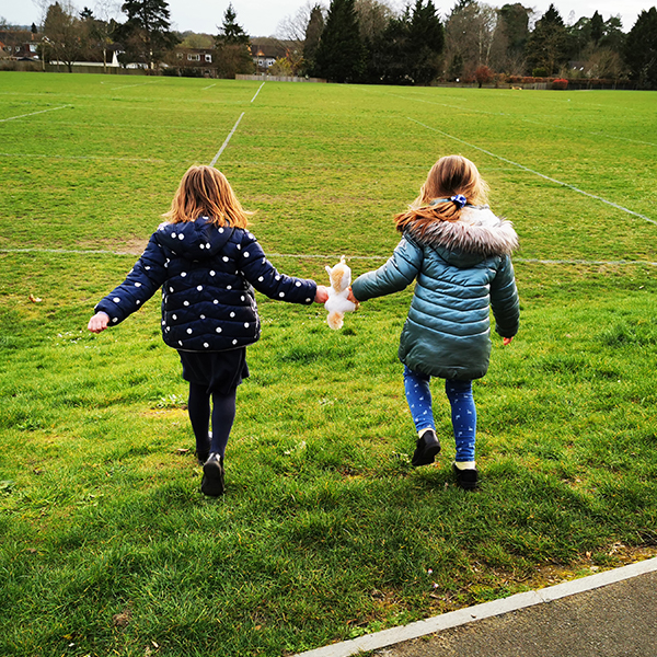 two girls running across field