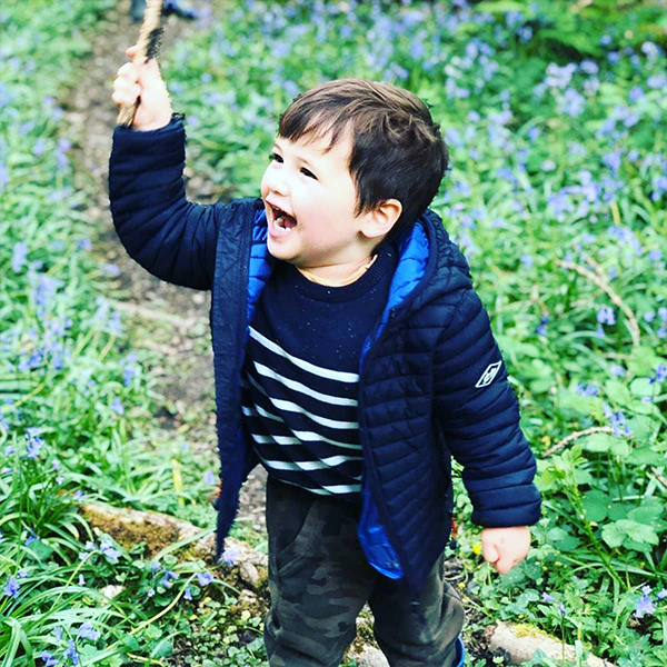 little boy smiling in the woods
