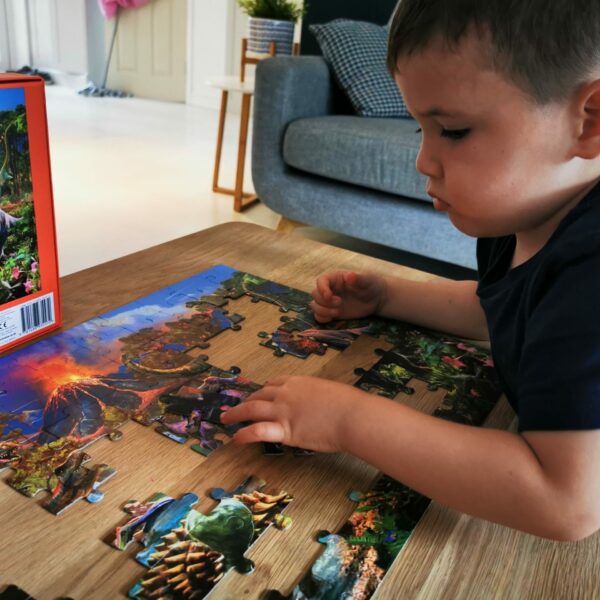 young boy playing with dinosaur puzzle