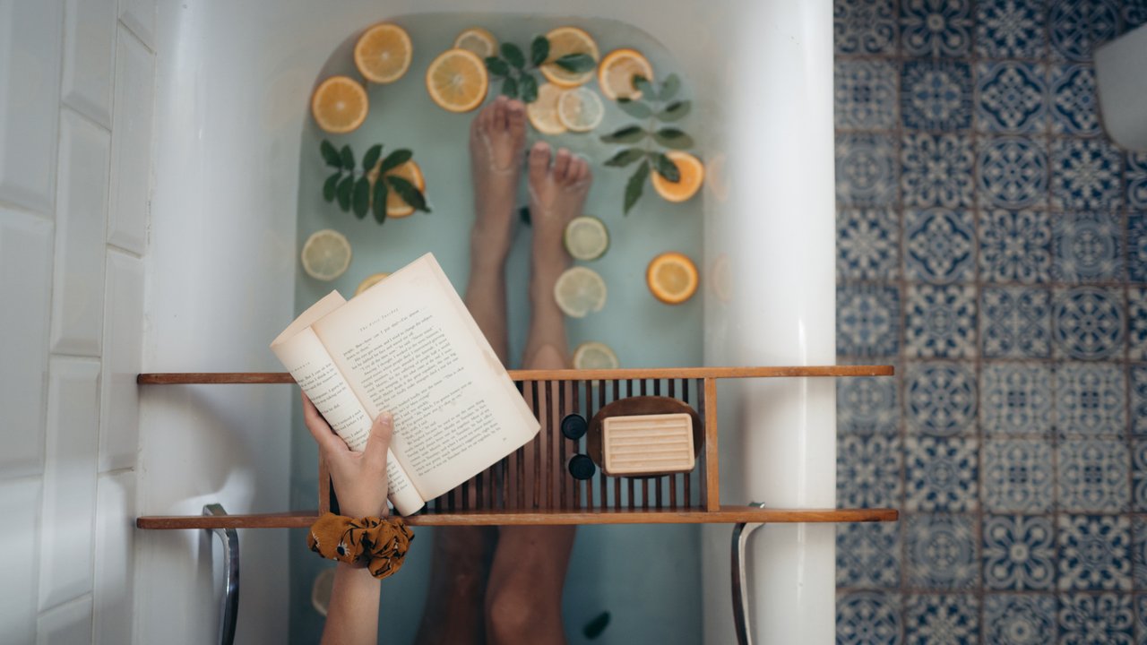 person holding book over relaxing bath