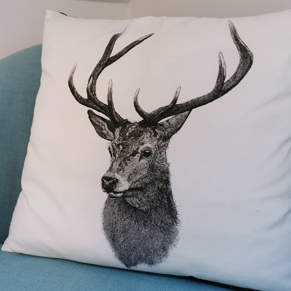 white cushion with a black deer pictureon it