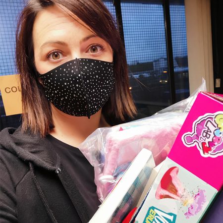 lady in face mask with toy boxes in hand