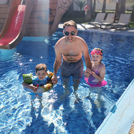 dad and two children in swimming pool