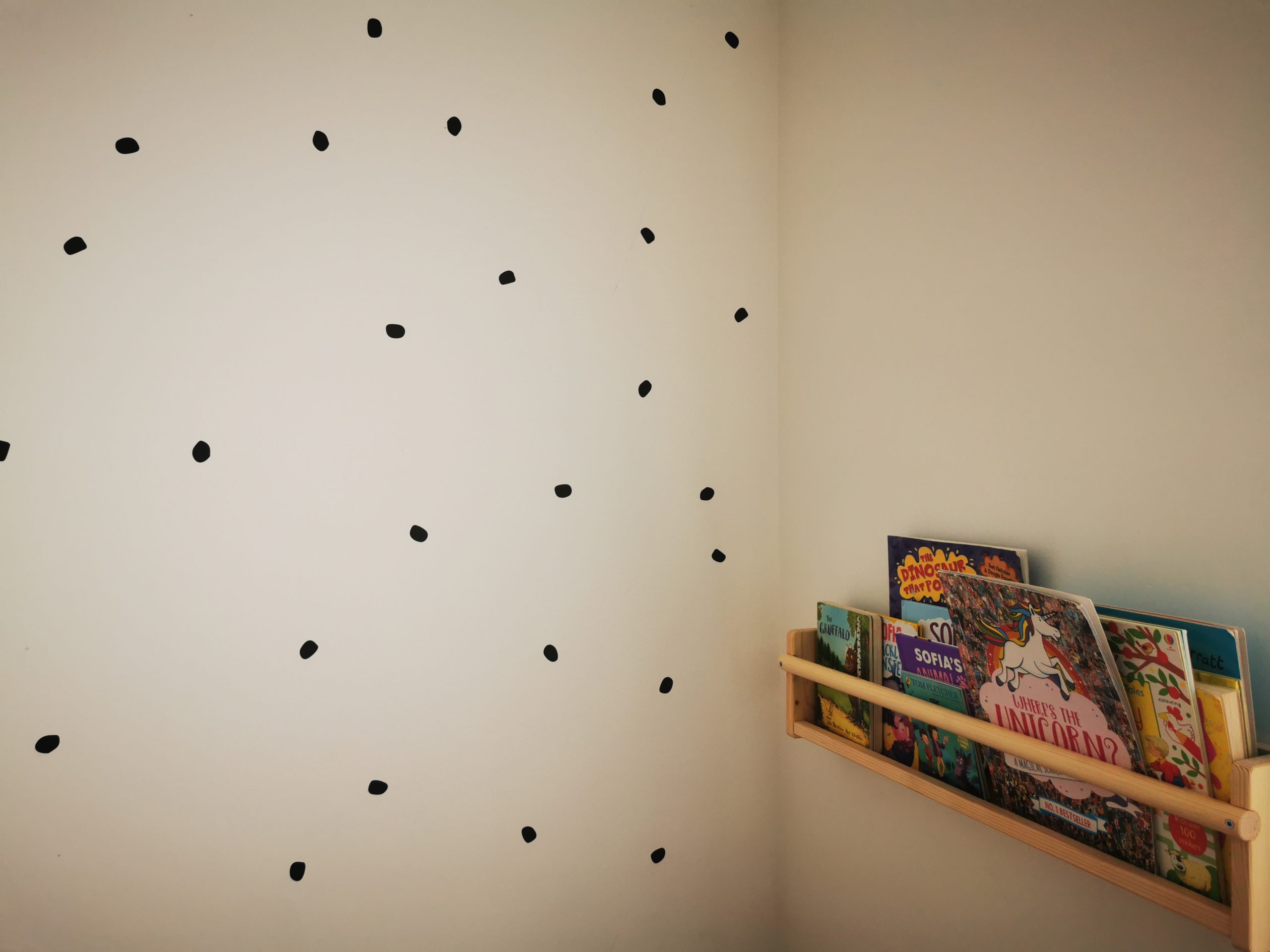 bookshelf next to spotty wall in playroom