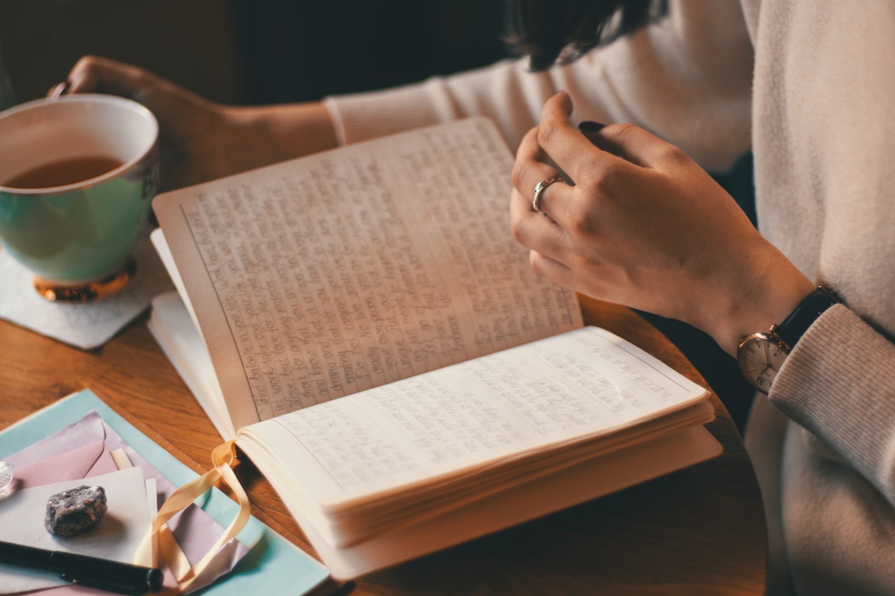 Lady sat at desk with tea and diary