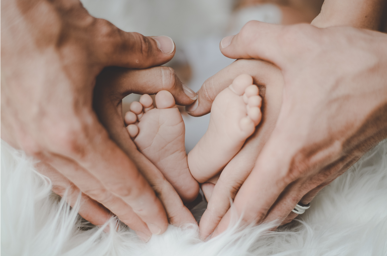 other and fathers hands holding babies feet
