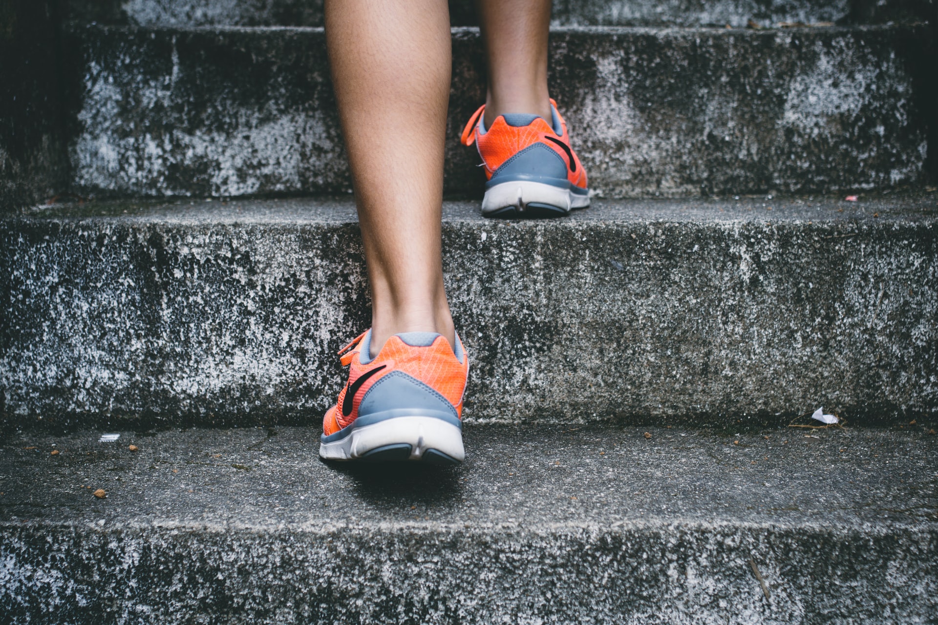 person running up steps in trainers