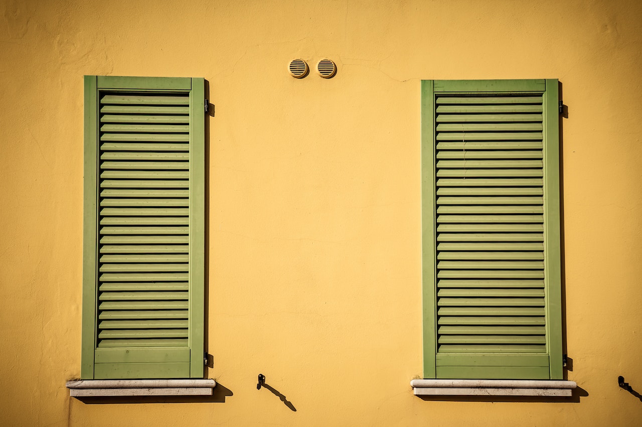 yellow building with green shutters