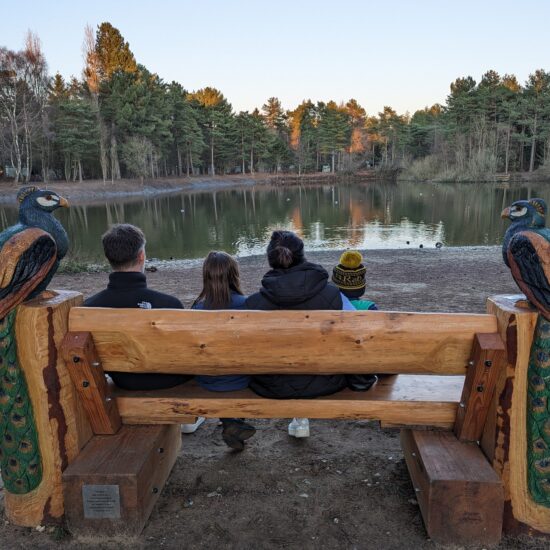 Family sat at lake in Center Parcs Elveden Forest