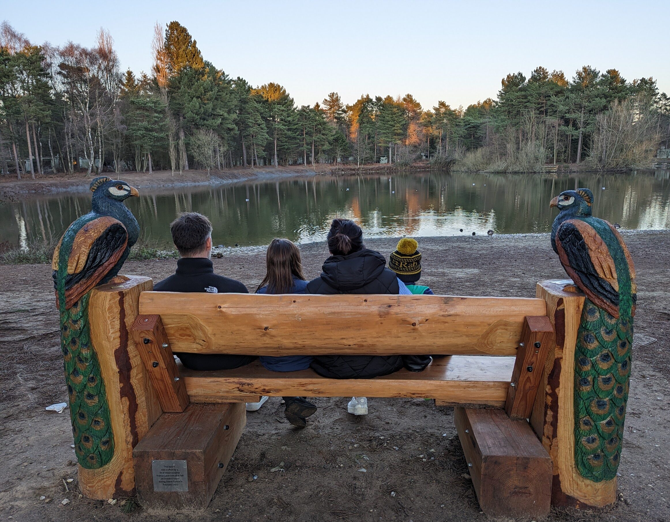 Family sat at lake in Center Parcs Elveden Forest